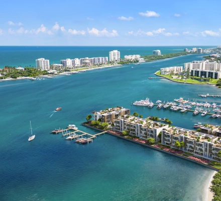 Aerial rendering of low-rise modern waterfront residences with rooftop terraces and a private boat dock on turquoise Intracoastal water, with a marina, high-rise condominiums and the Atlantic Ocean in the distance.