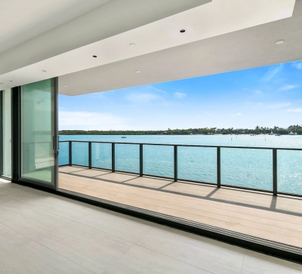 Open living with large window overlooking marina and boats