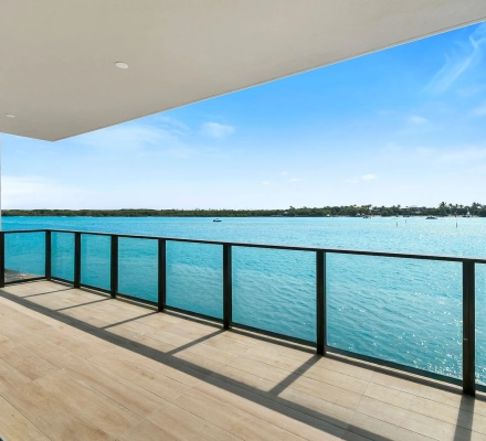 Empty living area looking out to covered waterfront balcony