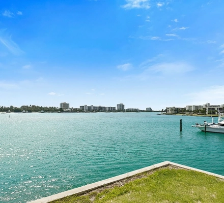 Corner balcony overlooking blue water, marina, and boats