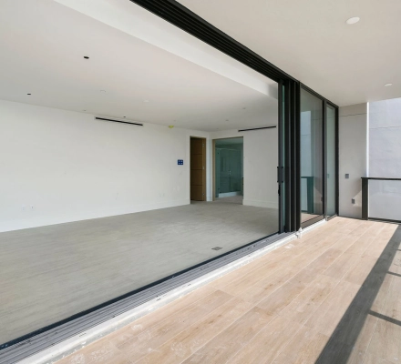 Balcony looking into empty room through open glass doors