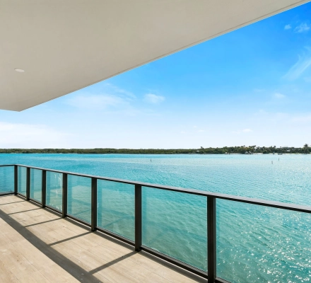 Covered balcony overlooking wide turquoise bay