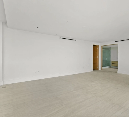 Empty room with open doorway leading to bathroom