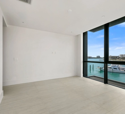 Small empty room with window overlooking marina boats