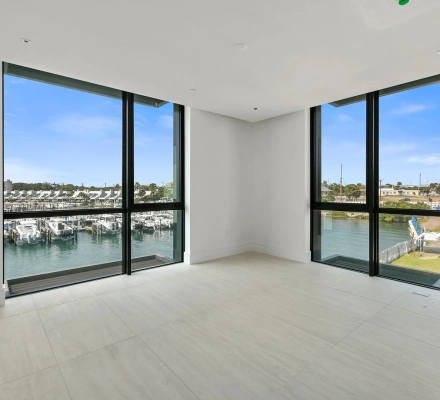 Corner room with two tall windows overlooking marina and water