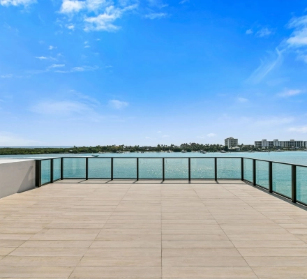 Rooftop terrace with glass railing overlooking marina