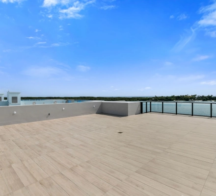 Rooftop terrace with glass railing overlooking marina