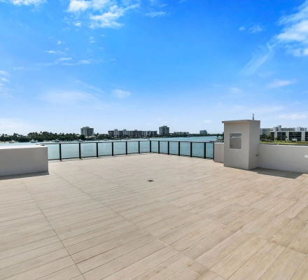 Rooftop terrace with glass railing overlooking marina