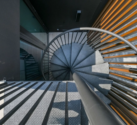 Spiral staircase with metal steps and wood slats