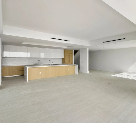 Unfurnished condo living area with modern kitchen and wood island