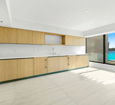 Modern galley kitchen with wood cabinets and water view window