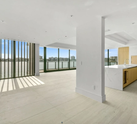 Open living area with kitchen island and waterfront windows